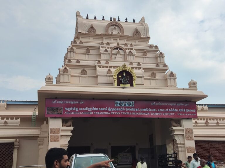 Entrance tower of the Lakshmi Narasimha Swamy Temple at Sholinghur in Tamil Nadu, with devotees and a car in front of the temple.